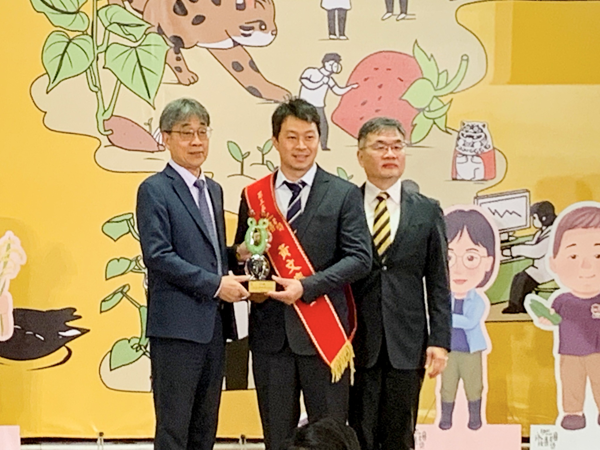 陳駿季代理部長(左)及防檢署邱垂章署長(右)共同頒獎予現場操作組得獎人黃文慶青農(中)。