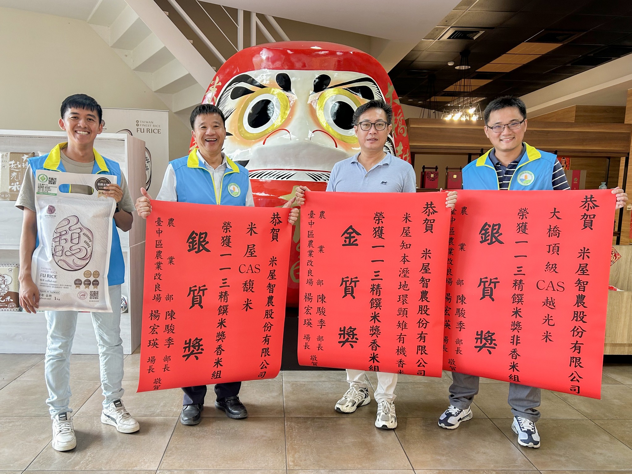 蕭政弘副場長(左2)代表楊宏瑛場長致贈紅榜，並與陳肇浩董事長(右2)合影留念表達祝賀之意(右1為吳以健副研究員，左1為鄧執庸助理研究員)。