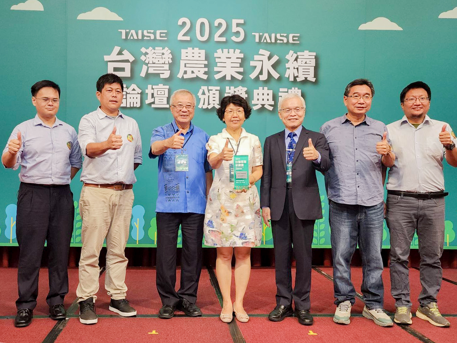 楊宏瑛場長(中)與陳保基前農委會主委(左3)、永續司莊老達司長(右3)及本場同仁於頒獎台一起合影。