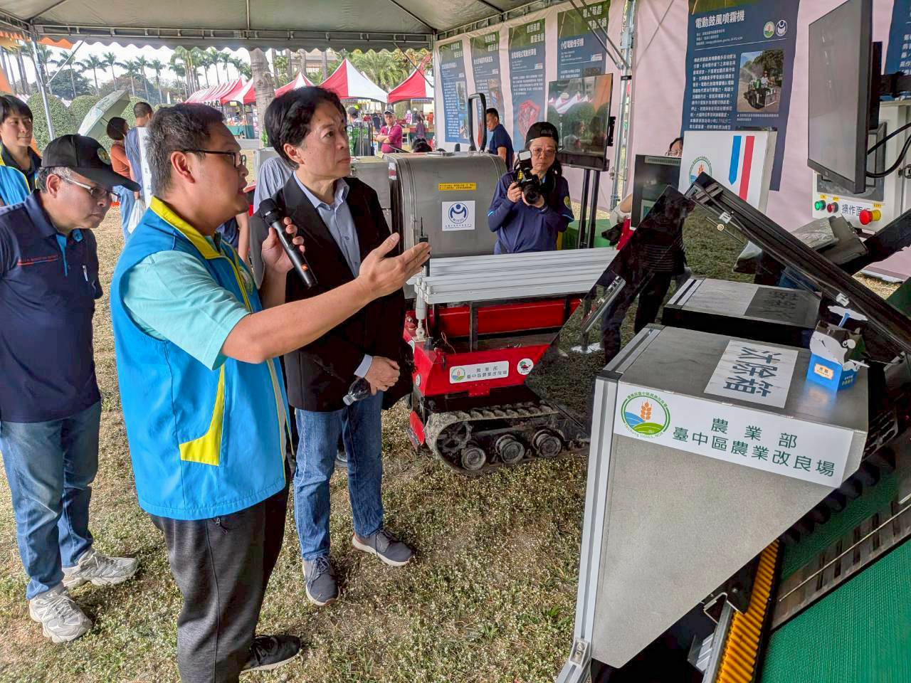 張佳偉助理研究員向林家榮主秘與羅正宗場長介紹穴盤苗篩選機。