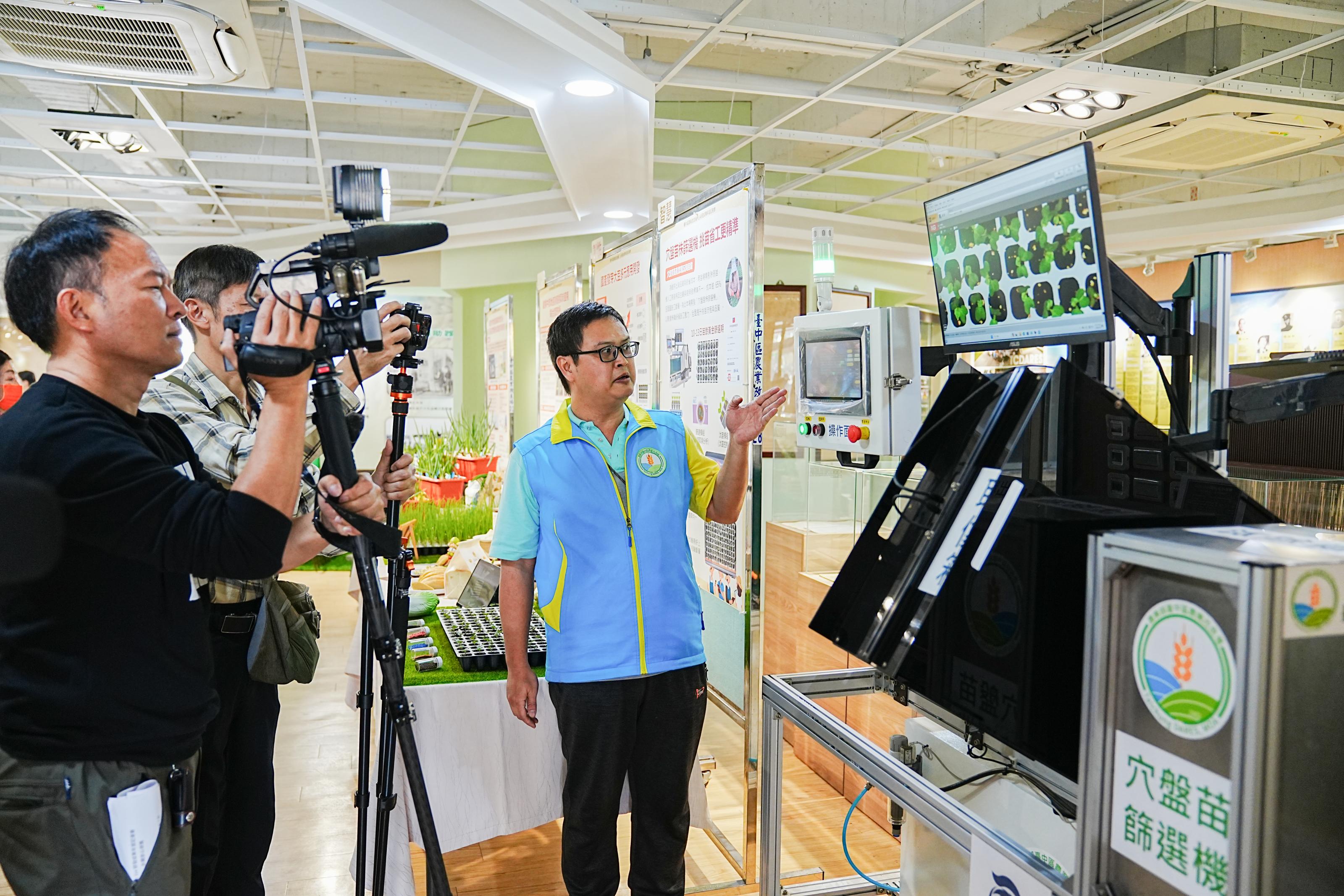 張佳偉助理研究員向媒體記者說明穴盤苗株篩選機成果。