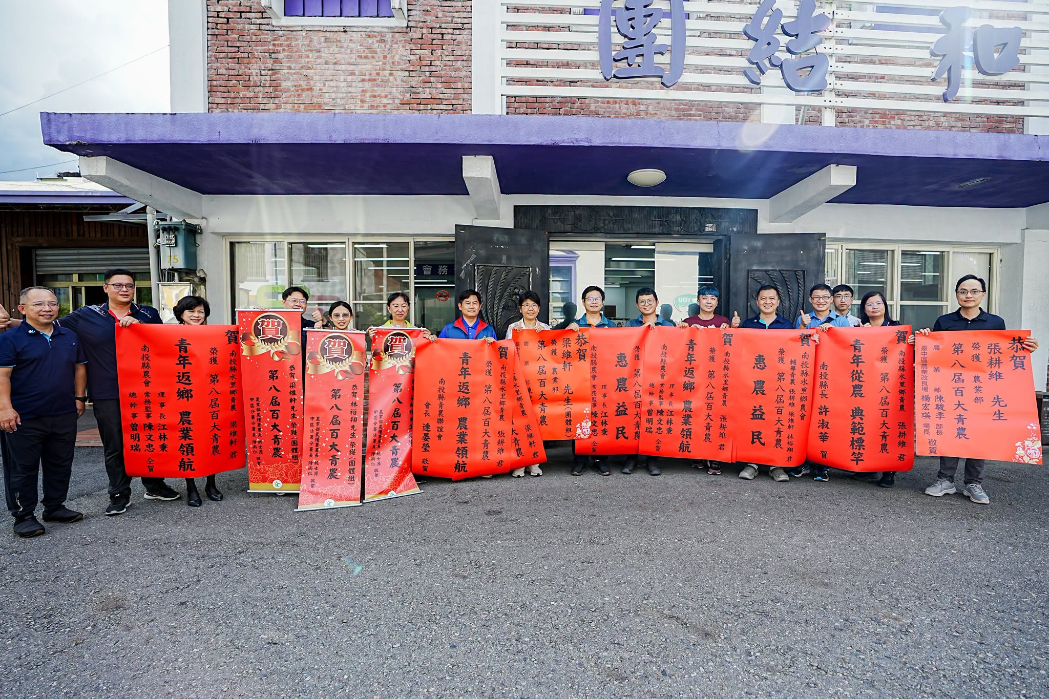 本場楊宏瑛場長(中)與農業推廣科吳建銘科長(右1)等人前往水里鄉農會張貼紅榜,祝賀青農張耕維(中右3)、梁維軒(中右2)、林裕翔(中右1)獲選農業部第八屆百大青農殊榮。