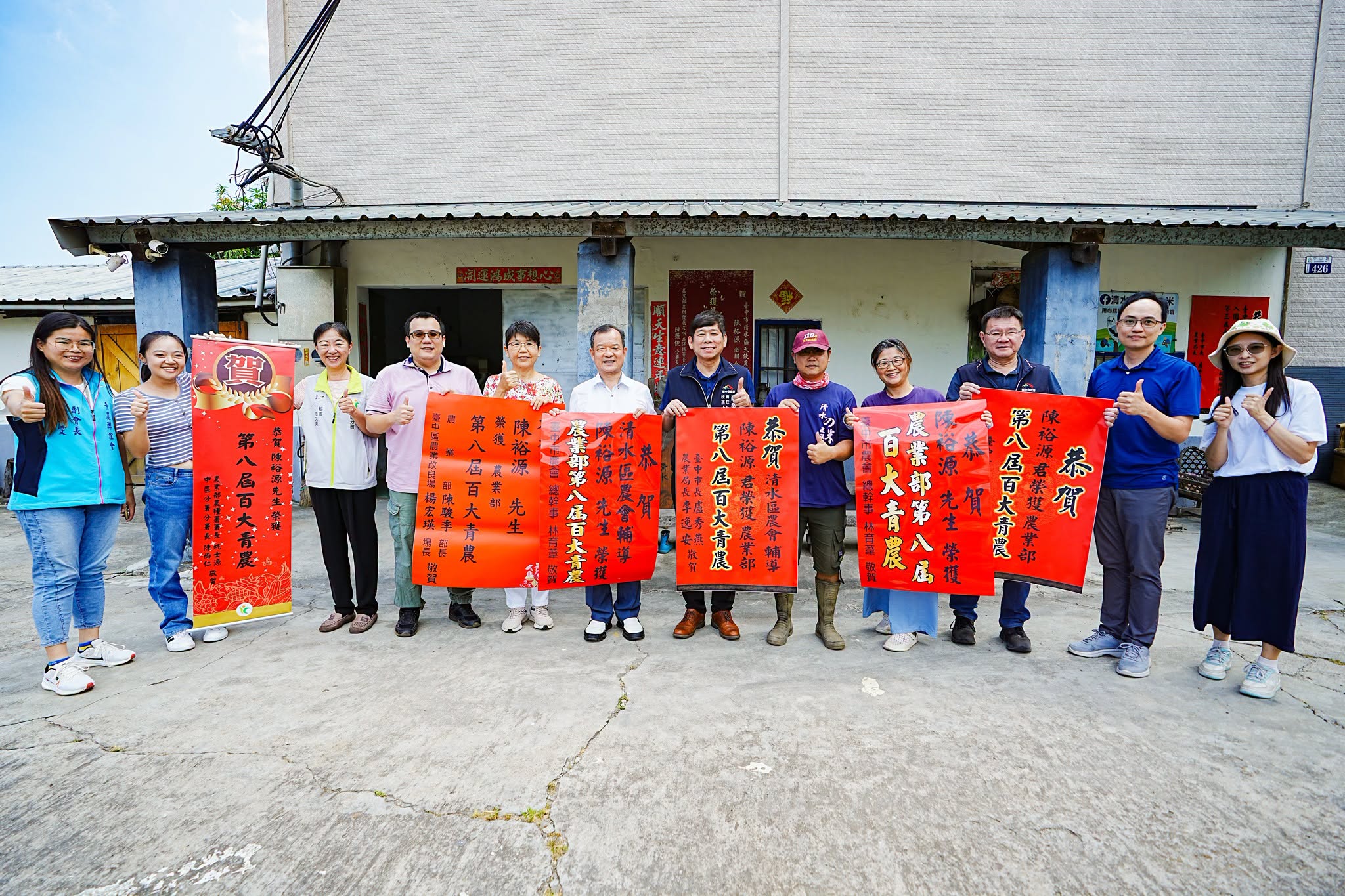 本場楊宏瑛場長(左5)與農業推廣科吳建銘科長(右2)等人前往后里區農會張貼紅榜,祝賀青農陳裕源(右5)獲選農業部第八屆百大青農殊榮。