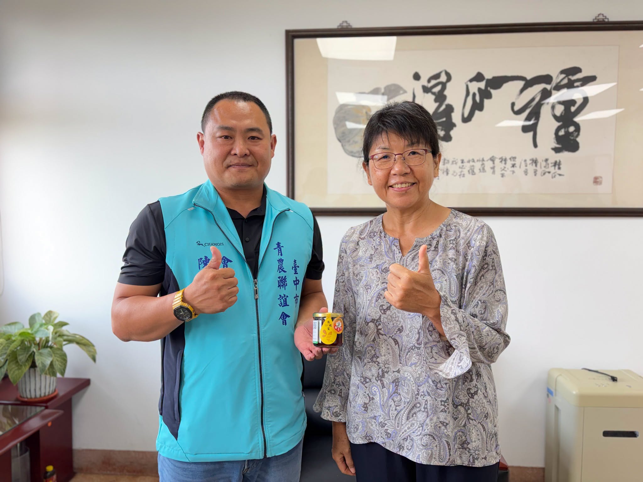 場長與青農會長陳明煌龍眼蜜產品合照。