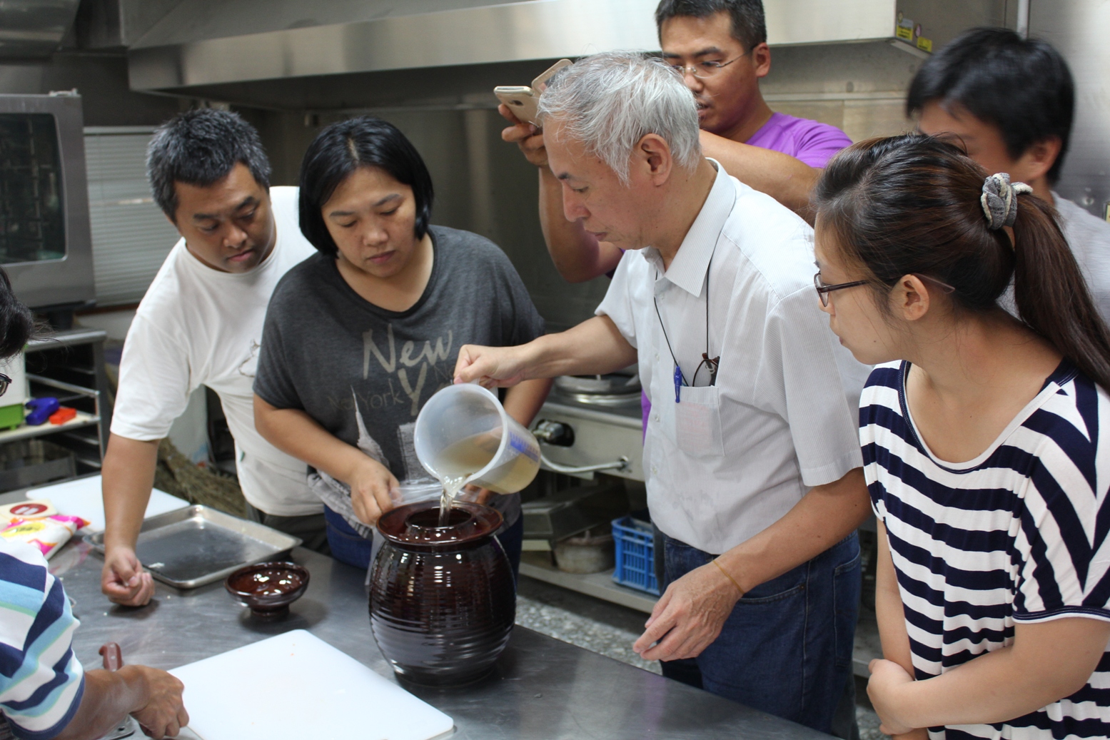 許明仁老師輔導青年農民利用泡菜甕製作泡菜，指導滷水之調配比率