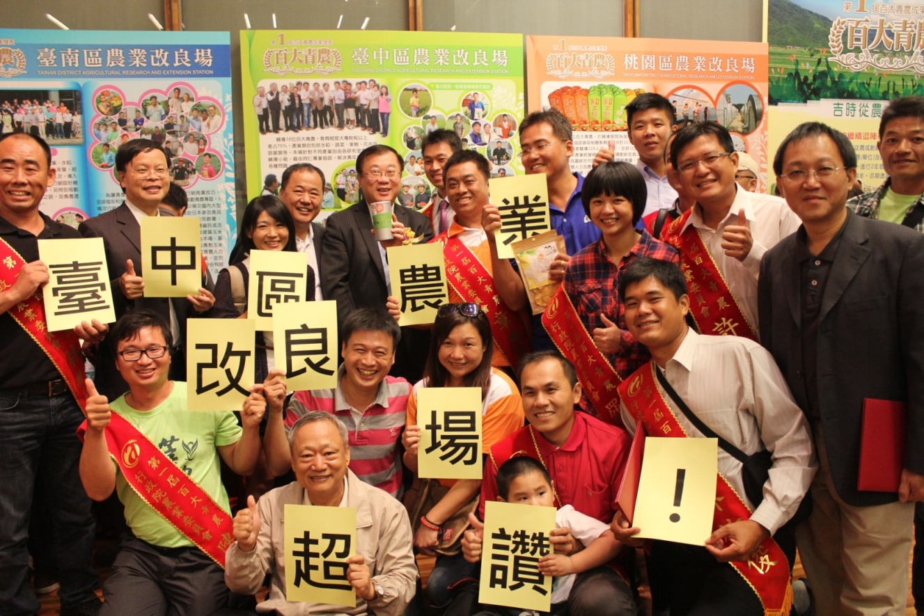 陳保基主委、張致盛處長及林學詩場長在本場佈展攤位前與第一屆及第二屆青年農民開心地合影 