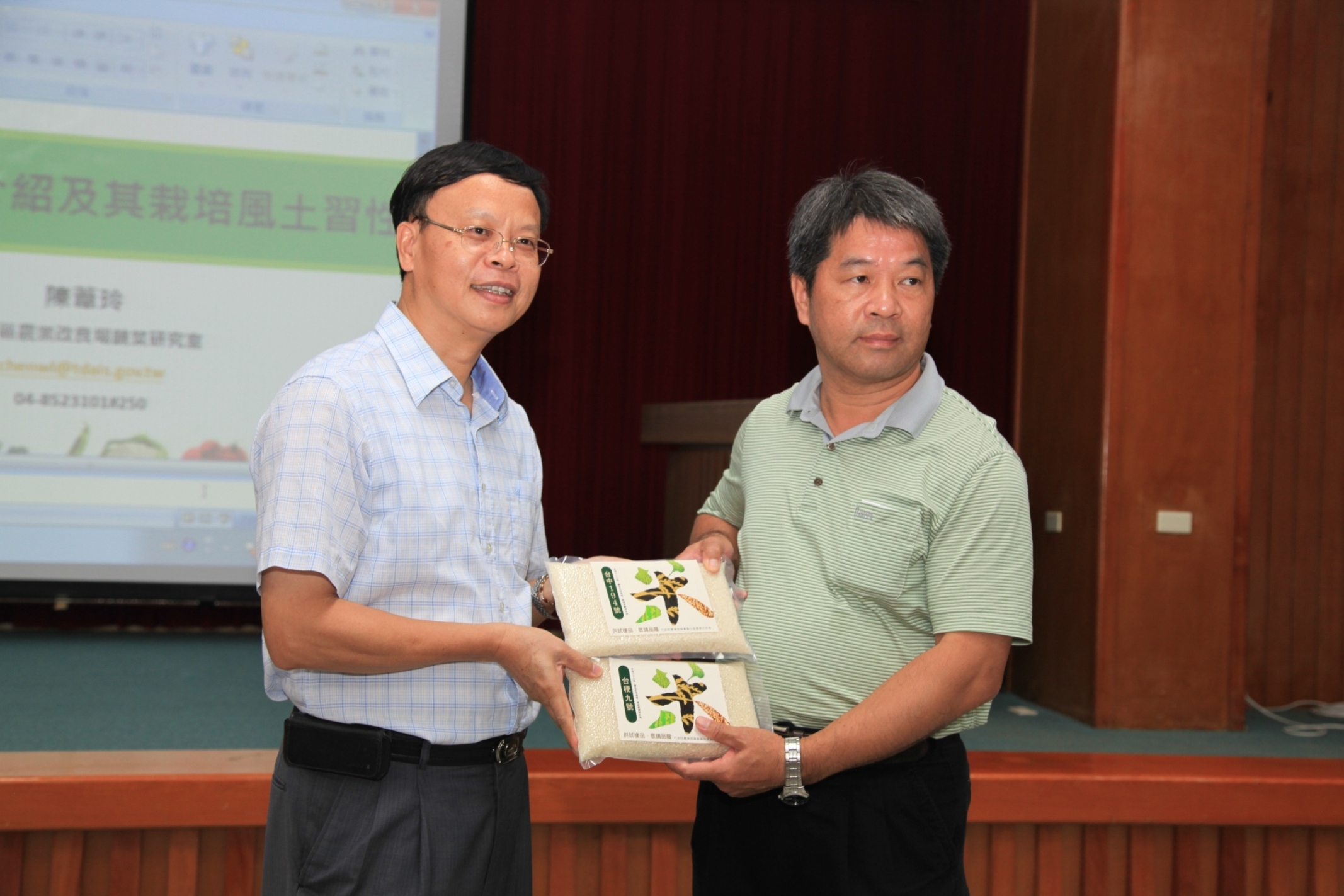 林學詩場長 ( 左一 ) 與臺灣宜蘭農田水利會管理組長游日發 ( 右一 ) 合照，並介紹本場研發水稻品種台稉 9 號及台中 194 號