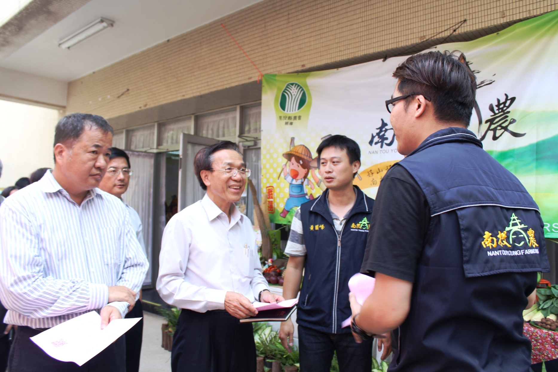 南投縣農會張育賢督導及本場輔導第二屆青年農民黃國峰向農委會陳文德副主委說明青農產品展示陳列情形 